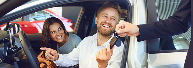 couple getting car keys from dealer