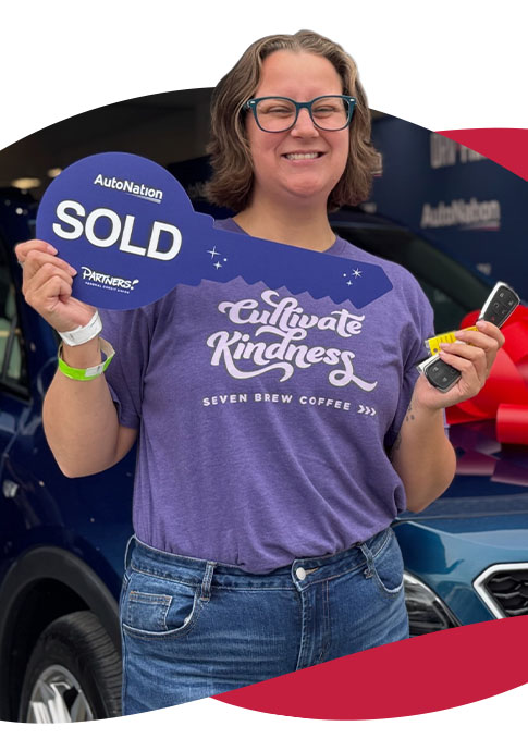 Member smiling holding sold sign