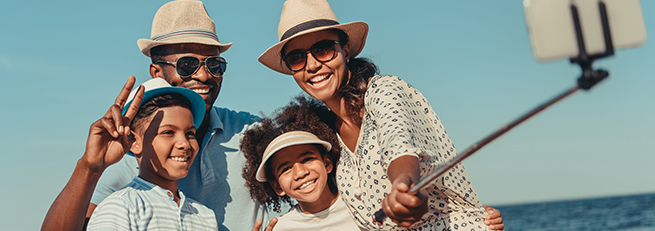Family posing for a picture with a cell phone